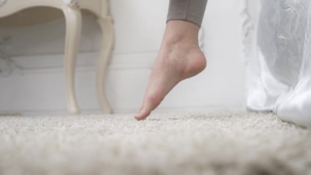 Close up shot of the womans first morning step from the bed to the carpet — Stock Video