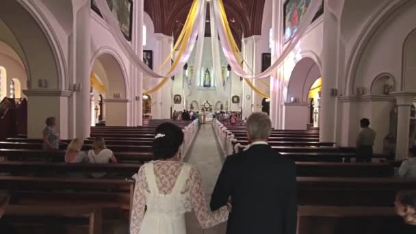 Padre lleva a su hija al altar de la iglesia — Vídeos de Stock