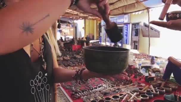Customer tries out indian souvenir sounding bowl — Stock Video