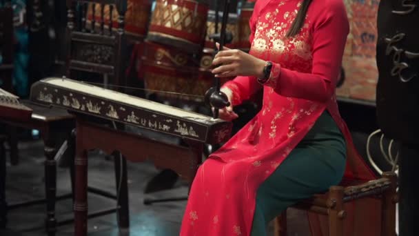 Asiatisk kvinna i nationell klänning spelar på folkliga instrument — Stockvideo