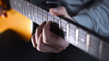 Gitarist akustik batı gitarında ölçek ve gama çalıyor.