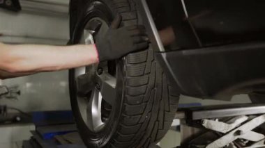 Tamirci araba servis istasyonunda süspansiyonu kontrol ediyor.