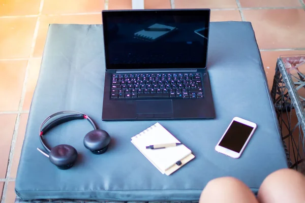 Working by black laptop computer with smart phone, and coffee cup with on wooden table