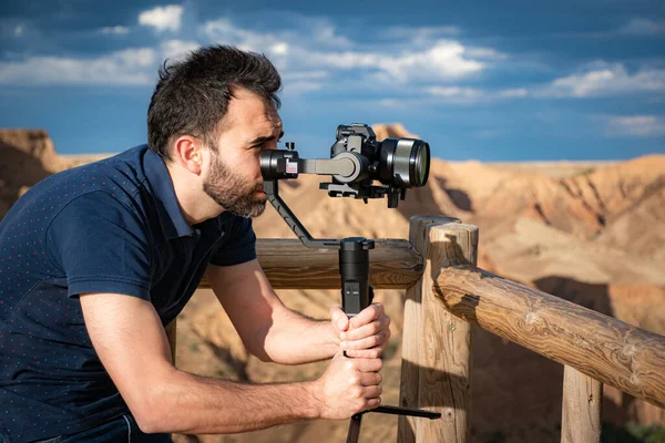 Genç sinemacı, büyük bir nehir ve bataklıklarla kanyondaki doğal manzarayı filme alıyor.