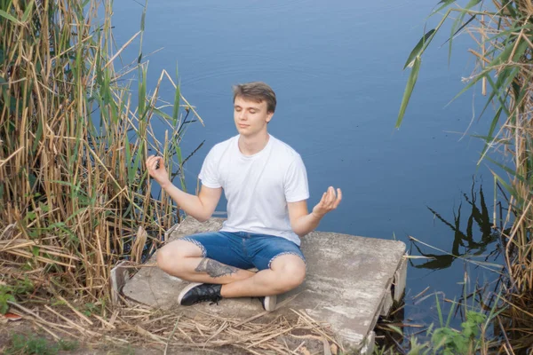 Молодой Человек Медитирует Берегу Озера — стоковое фото