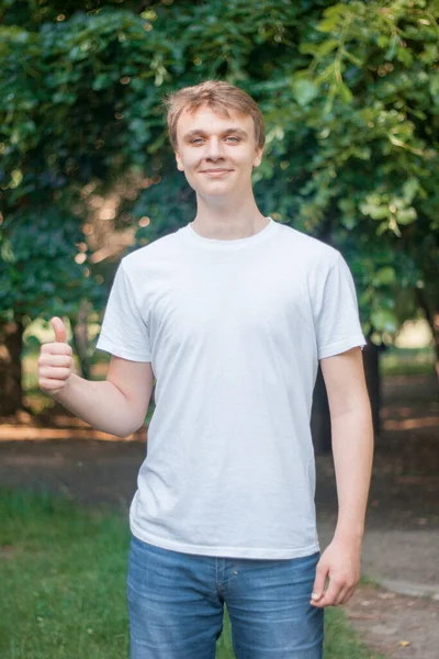 Szczęśliwy Młody Człowiek Podnosi Kciuki Patrzy Kamerę — Zdjęcie stockowe
