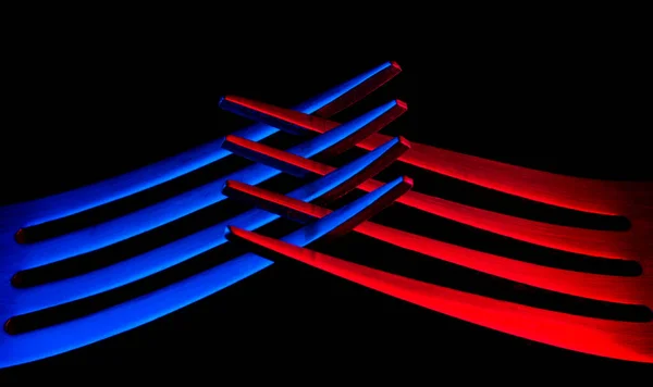 Siyah arka planı olan iki renkli çatal.