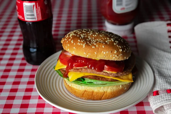 Hamburger ve kola, siyah arka plan.