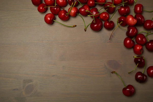 Green spring red cherries on wooden background selective focus cherry