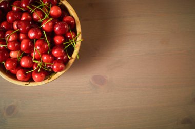 Ahşap zemin üzerinde yeşil bahar kırmızı kirazları seçici odak kirazı