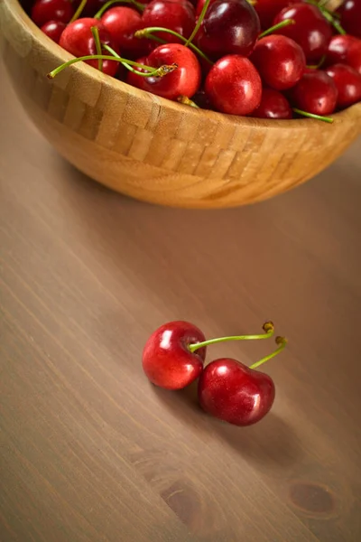 Grüne Frühling rote Kirschen auf hölzernem Hintergrund selektive Fokus Kirsche — Stockfoto