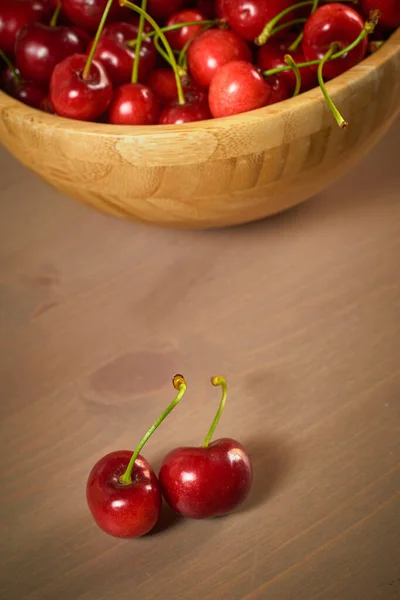 Зеленая весна красные вишни на деревянном фоне селективного фокуса вишни — стоковое фото