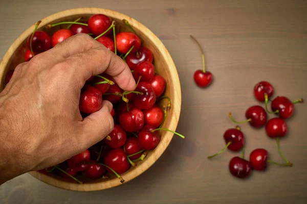 Красные вишни ручной пружины на деревянном фоне — стоковое фото