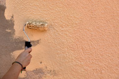 Evde krem silindirli el boyası duvar.