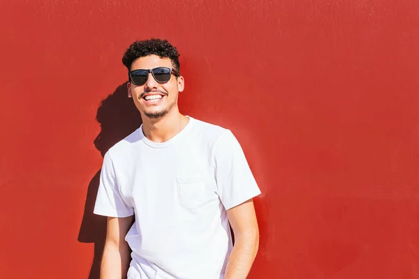 Potret Seorang Pemuda Dengan Kacamata Hitam Tersenyum Dinding Merah — Stok Foto
