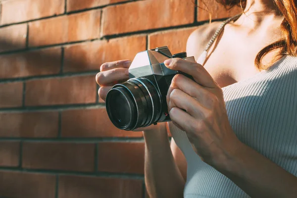 Analog fotoğraf makinesi tutan genç bir kadın.