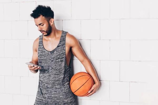 Anak Muda Melihat Smartphone Sambil Memegang Bola Basket — Stok Foto