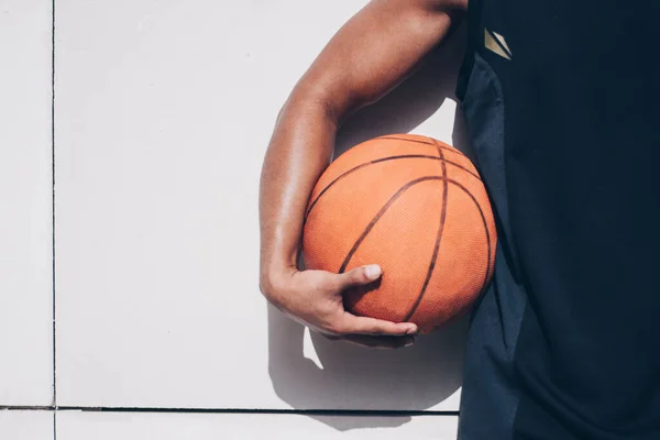 Genç adam elinde basketbol topu tutuyor.