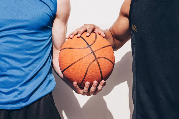 異なる人種の2人のバスケットボール選手が一緒にボールを持ち — ストック写真