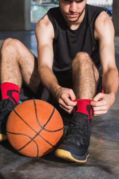 Genç adam basketbol oynamaya hazırlanıyor.