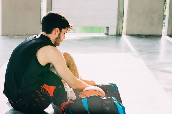 Genç adam basketbol oynamaya hazırlanıyor.
