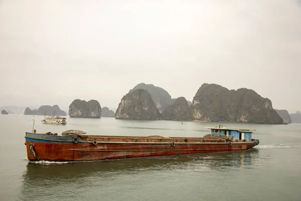 Barge and tourist boat in Ha Long Bay Vietnam