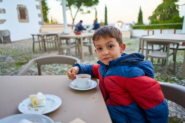 Çocuk abur cubur yerken tablete bakıyor