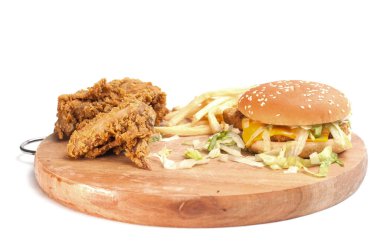 Kızarmış tavuklar, patates kızartmalı peynirli hamburgerler beyaz arka planda izole edilmiş tahta doğrama tahtaları..