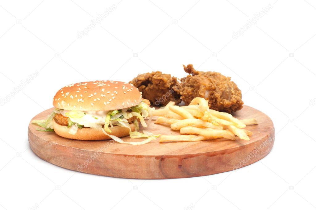 Fried chickens,cheese burger with fries on wooden chopping board isolated over white background.