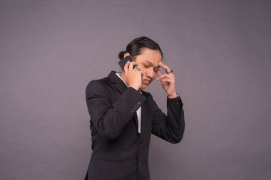 Stresli iş adamı telefona cevap verirken.