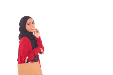 Beyaz arka planda izole edilmiş alışveriş torbaları tutan mutlu genç Müslüman kız..