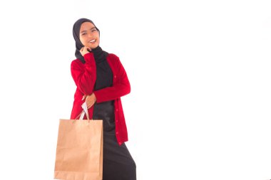 Beyaz arka planda izole edilmiş alışveriş torbaları tutan mutlu genç Müslüman kız..