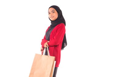 Beyaz arka planda izole edilmiş alışveriş torbaları tutan mutlu genç Müslüman kız..