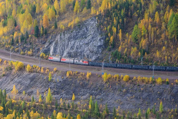 Sonbaharda Sibirya dağlarında bir yük treni demiryolu ile hareket eder..