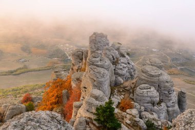 Rocks teeth on Demerdzhi - famous tourist Crimea. Sunrise over ancient rocks of the Black Sea in the background fog after heavy rain storms and rain is very beautiful clipart