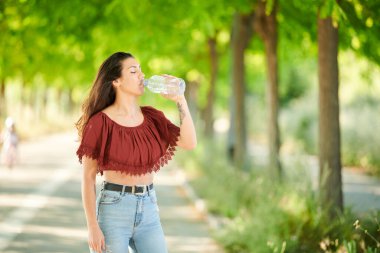 Rahat genç kız su içiyor.