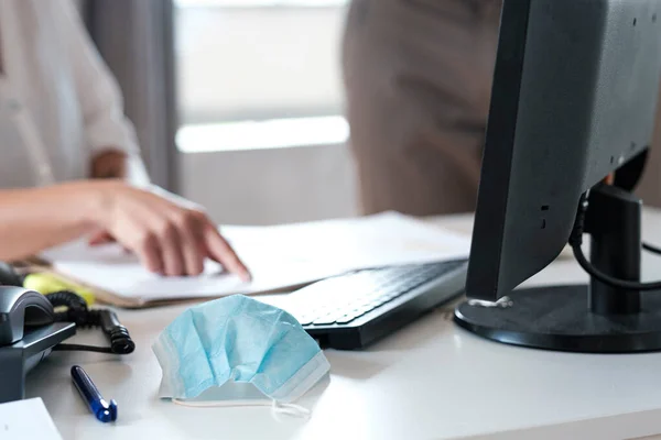 surgical mask on top of an office table