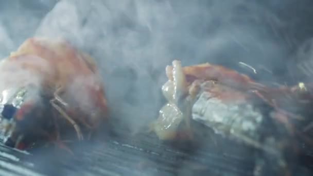 Tongs odwraca krewetki, które są grillowane z ziół i czosnku — Wideo stockowe