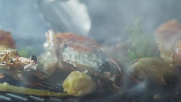 Tongs flips the prawns that are grilled with herbs and garlic Stock Video