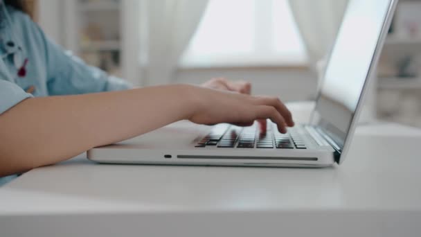 Masada dizüstü bilgisayar kullanan genç bir üniversite öğrencisi, dizüstü bilgisayarda çalışan bir kadın, klavyede çalışan bir kadın, bilgisayarla çalışan, uzaktan eğitim kavramı yavaş çekim yakın çekim. — Stok video