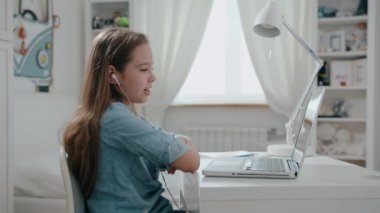 Mutlu genç bir kadın web kamerasıyla konuşuyor ve uzaktan video konferans görüşmesi yapıyor. Kadın internet öğretmeni evde uzaktan eğitim sohbeti yapıyor. Uzaktan öğrenme konsepti. Web kamerası görünümü