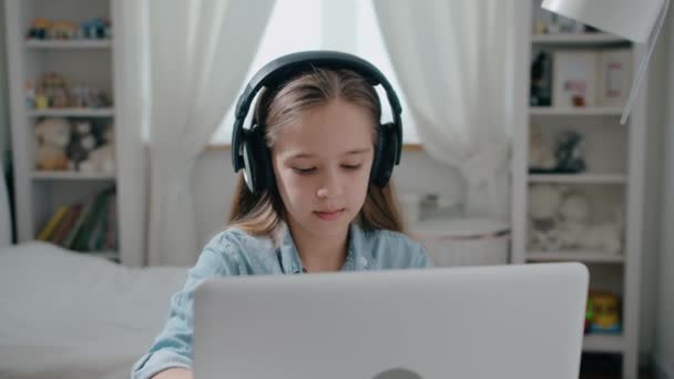 Piękna uczennica w studium słuchawkowym online z nauczycielem Internetu nauczyć patrząc na laptopa, koncepcja kształcenia na odległość slow motion — Wideo stockowe