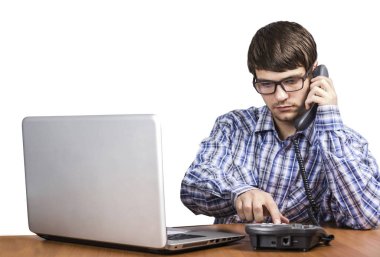 adam gözlük ve telefonda konuşurken bilgisayar ile masada oturan gömlek