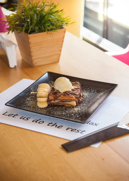 Chocolade Wafel Gegarneerd Met Ijs Banaan Decoratie Zwarte Plaat — Stockfoto