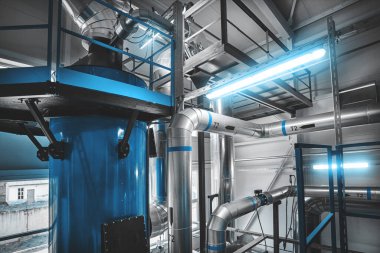 Katı haldeki çip kazanı için yakıt tedarik borularıyla ekonomizatör yoğunlaştırılıyor. Mavi tonlama