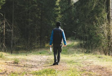 Postlu bir adam karantinadan sonra maskesini çıkarır, ormanda yalnız yürümekten zevk alır. Koronavirüsün sonu, tecrit ve normal hayatın başlangıcı. Arkadan bak. Konsept üzerine karantina