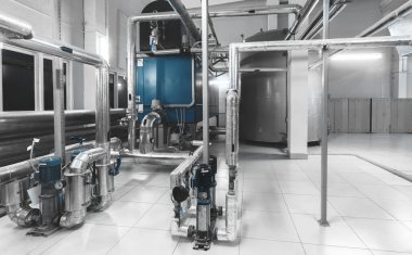 Kazan, pompa, basınç göstergeleri ve gaz ve buhar boruları olan modern endüstriyel kazan dairesi. Mavi tonlama