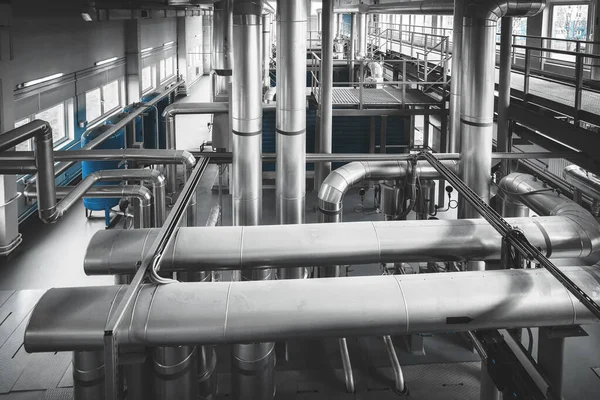 Interior of modern industrial boiler room with gas boilers and pipes for supplying gas and steam. View from above. Blue toning