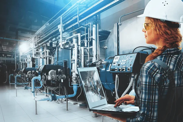 Dizüstü bilgisayarlı mühendis kadın modern endüstriyel gaz kazan dairesini inceliyor. Isıtma kazanları, boru hatları, vanalar. Mavi tonlama ve güneş ışığı. Karışık ortam