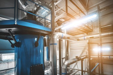 Katı haldeki çip kazanı için yakıt tedarik borularıyla ekonomizatör yoğunlaştırılıyor. Fişekli mavi tonlama 